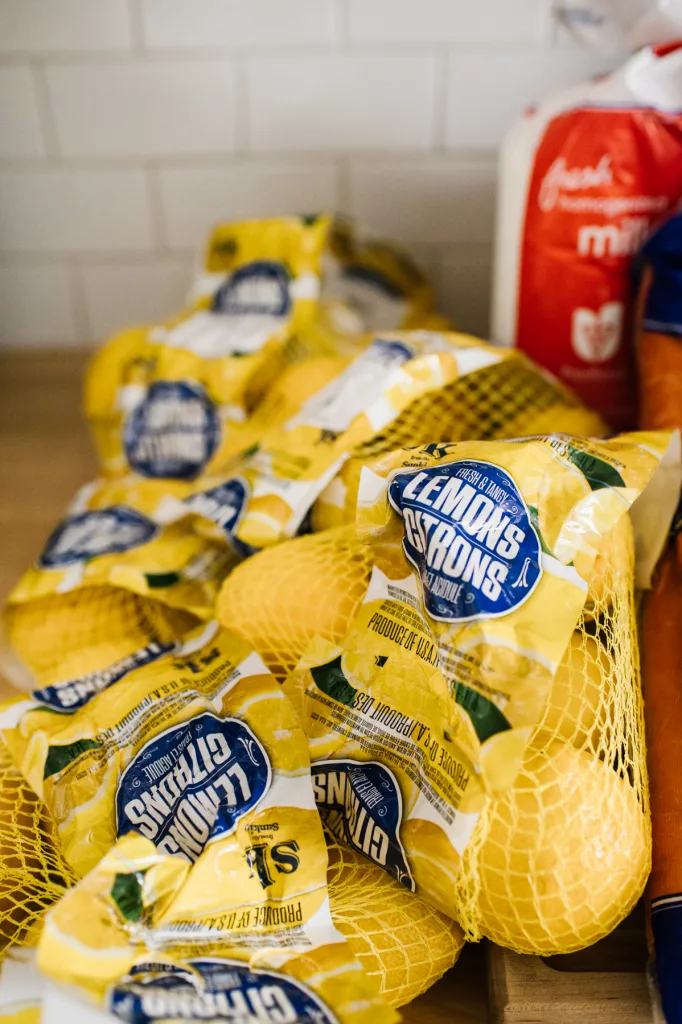 six bags of lemons on a butcher block counter