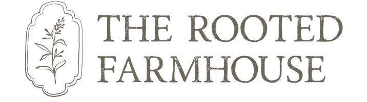 The logo for The Rooted Farmhouse features hand-drawn text with a simple sketch of a leafy plant inside a decorative frame to the left of the wording.